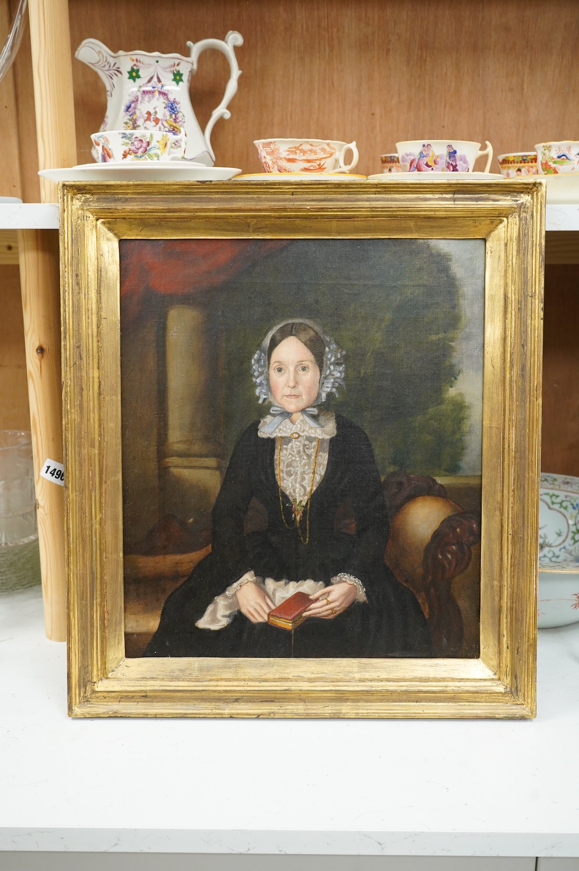 Victorian school, Portrait of a lady in mourning before a landscape, oil on canvas, 40 x 35cm, gilt framed